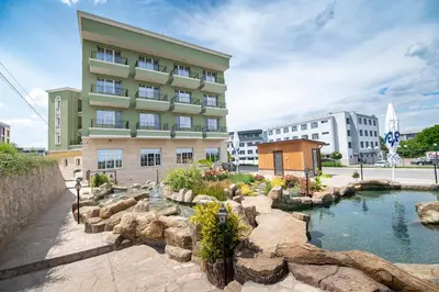 a hotel with a pond in front of a building at Glamping Alliance Hotel in Plovdiv