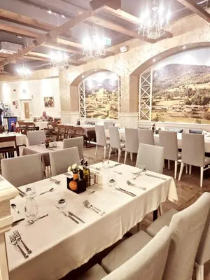 a dining room with white tables and chairs and windows at Glamping Alliance Hotel in Plovdiv