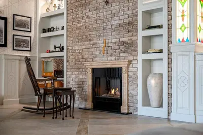 a brick fireplace in a living room with a table and a chair at Glamping Alliance Hotel in Plovdiv
