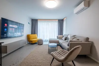 a living room with a couch and chairs and a tv at Emirates Luxury Apartment Free Parking Terrace in Sofia