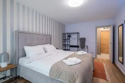 a bedroom with a large bed with two towels on it at Emirates Luxury Apartment Free Parking Terrace in Sofia