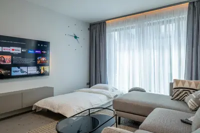 a living room with a couch and a tv at Emirates Luxury Apartment Free Parking Terrace in Sofia