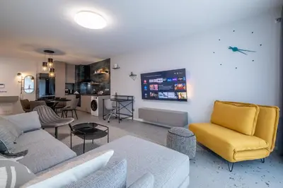 a living room with a couch and a yellow chair at Emirates Luxury Apartment Free Parking Terrace in Sofia