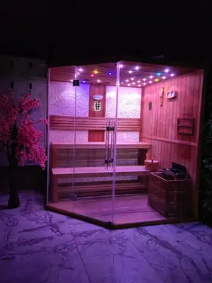 a sauna with a shower in a room with purple lights at Вилно селище PARADISE VIEW in Sarnitsa