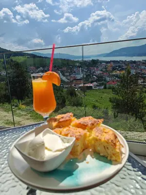 a plate of food on a table with a drink at Вилно селище PARADISE VIEW in Sarnitsa
