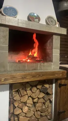 a brick oven with a fire inside of it at Къща за гости НОВЕ in Terziysko