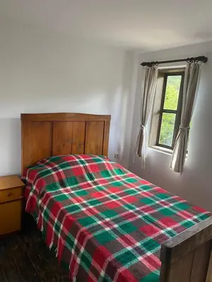 a bedroom with a bed with a plaid blanket at Къща за гости НОВЕ in Terziysko