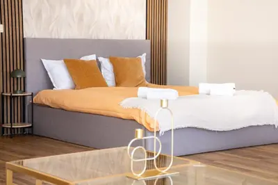 a bed with orange and white pillows and a glass table at !!!1min From The Lift I Luxury Studio In Pirin Palace in Bansko