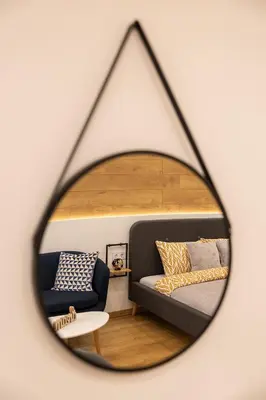 a mirror reflecting a bedroom with a bed and a couch at Luxury Studio Living High-End Amenities and Great Location by Flat Mаnager in Sofia