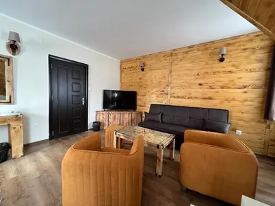 a living room with a couch and a table and chairs at Nicole Hotel & Restaurant in Samokov