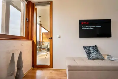 a living room with a couch and a flat screen tv at Peaceful Condo w/ Amazing View in Bansko