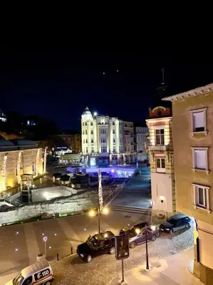 a city at night with cars parked on a street at Студио Римски Стадион in Plovdiv