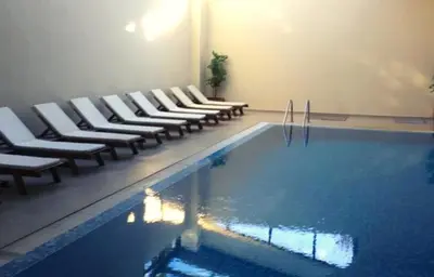 a swimming pool with lounge chairs and a swimming pool at Aspen Golf Resort and SPA in Bansko