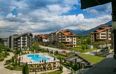 a resort with a swimming pool and some buildings at Aspen Golf Resort and SPA in Bansko