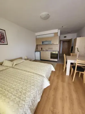 a bedroom with a bed and a table and a kitchen at Aspen Golf Resort and SPA in Bansko
