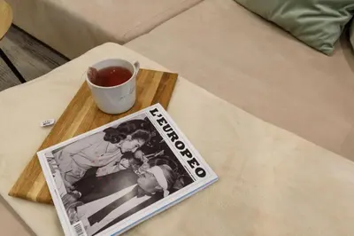 a magazine on a table next to a cup of tea at Apartment BonBon next to Gondola in Bansko