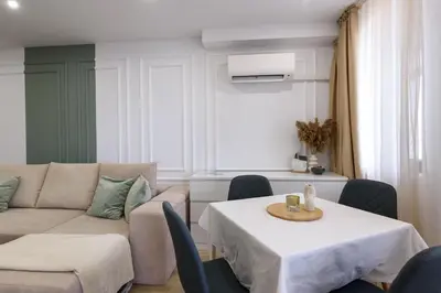 a living room with a couch and a table and chairs at Apartment BonBon next to Gondola in Bansko