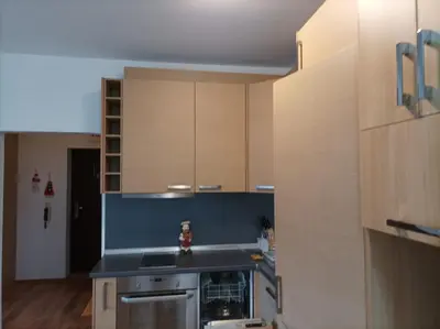 a kitchen with wooden cabinets and a stove top oven at Apartment 2 Detelina Residence in Bansko