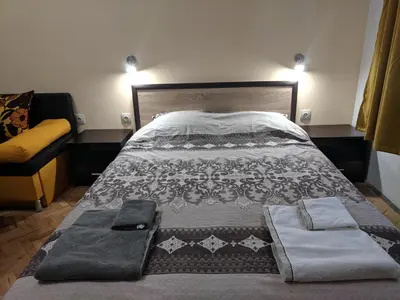 a bedroom with a bed with a blanket and a couch at Convenient New Apartment Near Metro Station by Flat Mаnager in Sofia