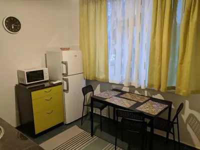 a small kitchen with a table and a refrigerator at Convenient New Apartment Near Metro Station by Flat Mаnager in Sofia