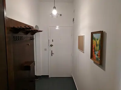 a hallway with a white door and a painting on the wall at Convenient New Apartment Near Metro Station by Flat Mаnager in Sofia