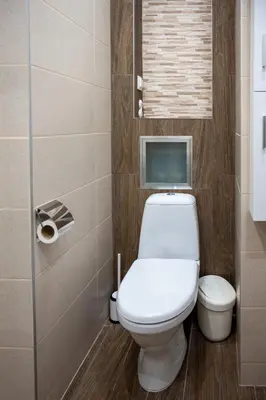 a bathroom with a toilet and a tv on the wall at Modern and Cozy 1BDR Apartment in the City Center in Sofia