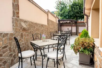 a row of tables and chairs on a patio at Beluga Guest House in Velingrad
