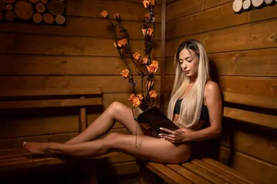 a woman sitting on a bench reading a book at Beluga Guest House in Velingrad