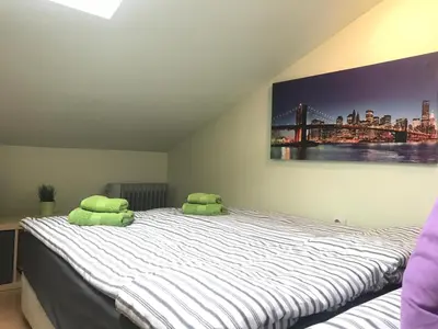 a bedroom with a bed with two green pillows on it at The Backpacker's Spot - Bus & Railway Station Gem by Flat Mаnager in Sofia