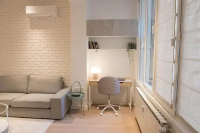 a living room with a couch and a desk at Top Center Designer Studio Apartment in Sofia