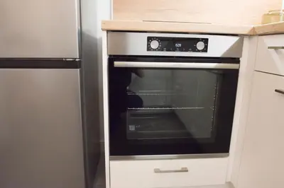 an oven in a kitchen next to a refrigerator at Top Center Designer Studio Apartment in Sofia