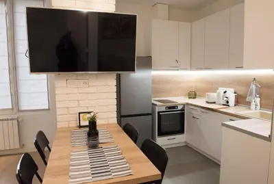 a kitchen with a table with chairs and a television above it at Top Center Designer Studio Apartment in Sofia