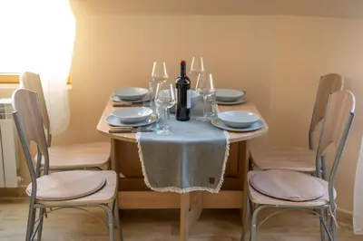 a dining room table with a bottle of wine and two chairs at Design Loft in the City Center in Sofia