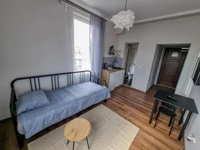 a living room with a bed and a table at Cozy Apartment in Sofia Center in Sofia