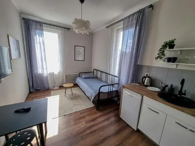 a room with a bed and a kitchen with a table at Cozy Apartment in Sofia Center in Sofia
