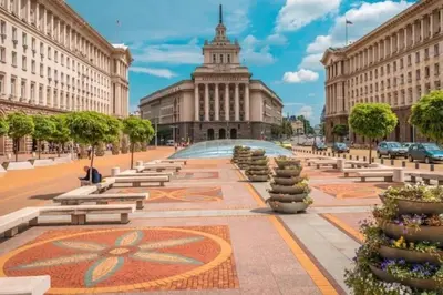 a city square with benches in front of a building at Cozy 1-Bedroom flat in the very Center of Sofia in Sofia