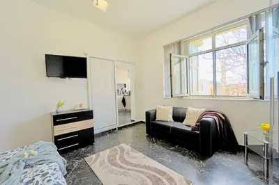 a living room with a couch and a tv at Cozy 1-Bedroom flat in the very Center of Sofia in Sofia