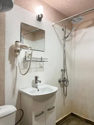 a white bathroom with a sink and a shower at Time Traveling Apartment Sofia Mladost District in Sofia