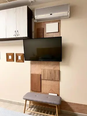 a living room with a bench and a tv on a wall at Time Traveling Apartment Sofia Mladost District in Sofia