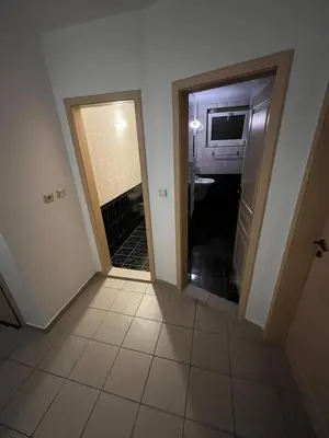 a hallway with a door leading to a bathroom with a sink at Хотел ПАНОРАМА ДОСПАТ in Dospat