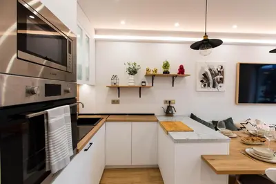 a kitchen with white cabinets and a stove top oven at Modern Mountain Getaway in Bansko