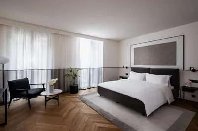 a bedroom with a large bed and a chair at Juno Hotel Sofia, a Member of Design Hotels in Sofia