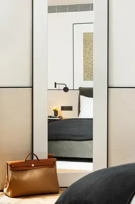 a bedroom with a view of a bed with a mirror at Juno Hotel Sofia, a Member of Design Hotels in Sofia