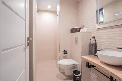 a white bathroom with a toilet and a sink at Лиловата Къща in Kalofer