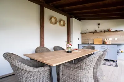 a dining room with a wooden table and chairs at Лиловата Къща in Kalofer