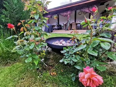 a garden with a bowl of rocks and flowers at Лиловата Къща in Kalofer