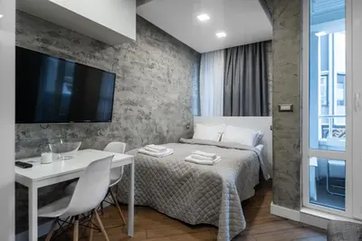 a bedroom with a bed and a table and a tv at Luxury Studio Silver by Flat Mаnager in Sofia
