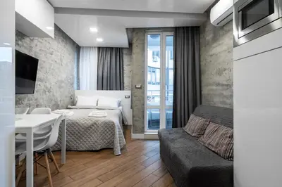 a bedroom with a bed and a table and a couch at Luxury Studio Silver by Flat Mаnager in Sofia