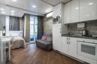 a kitchen with white cabinets and a bed in a room at Luxury Studio Silver by Flat Mаnager in Sofia