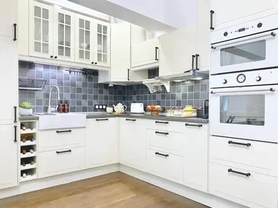 a white kitchen with white cabinets and stainless steel appliances at Vintage Top Centre Apartment in Sofia